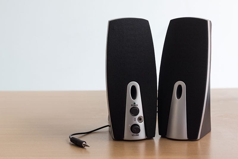 A pair of PC speakers sitting on a desk
