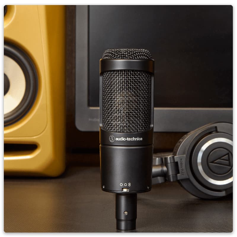 Audio-Technica AT2050 microphone with headphones and a studio monitor.