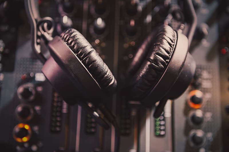 A pair of headphones sitting on top of a DJ mixer