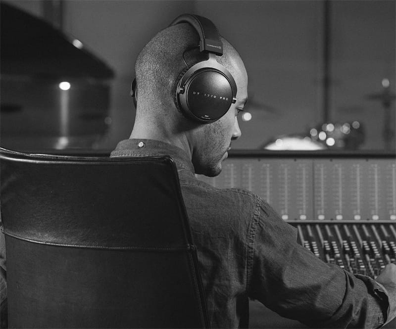 Man wearing Beyerdynamic DT 1770 Pro headphones in a music studio.