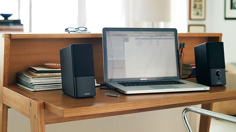 Bose Companion 2 Series III sitting on a desk with a laptop in the middle.