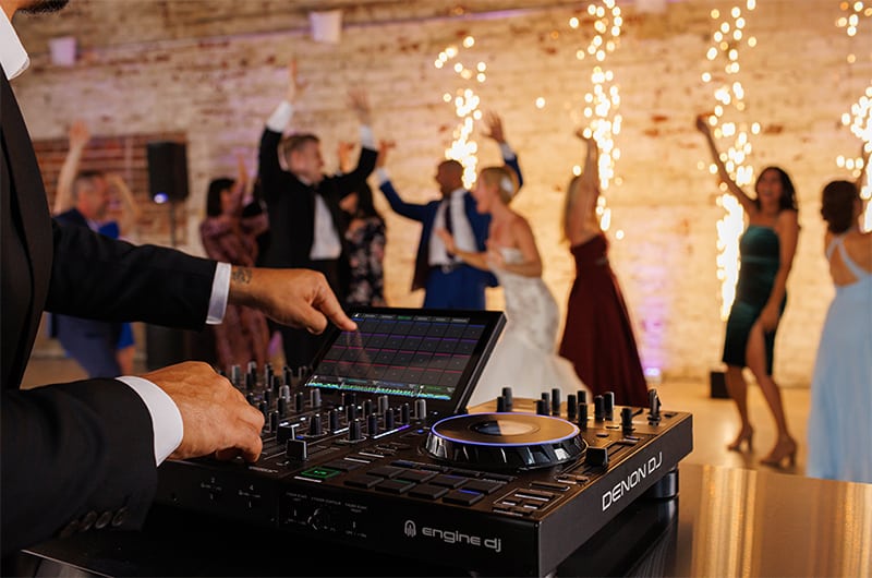 DJ using a Denon Prime 4 Plus at a wedding reception.