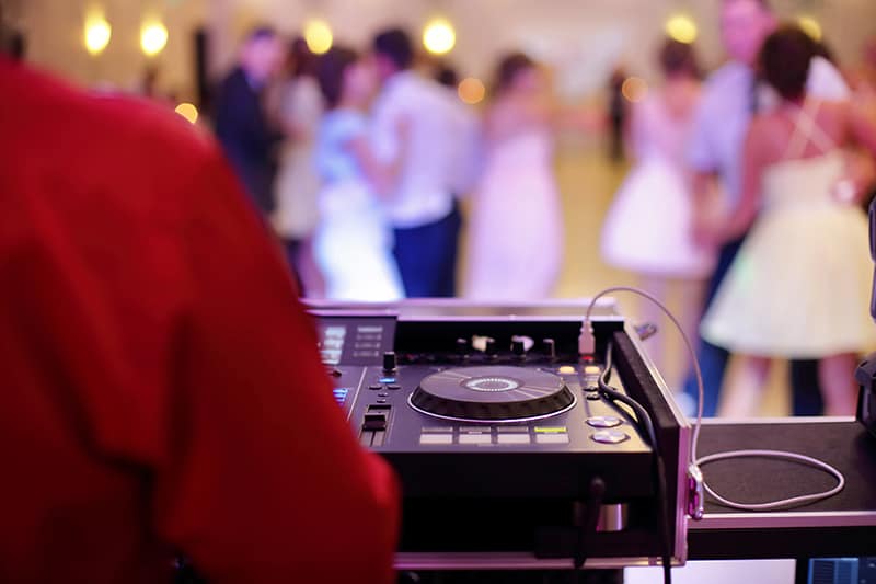 Man using DJ equipment at a wedding.