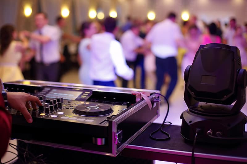 Wedding Dj with dancing couples in the background.