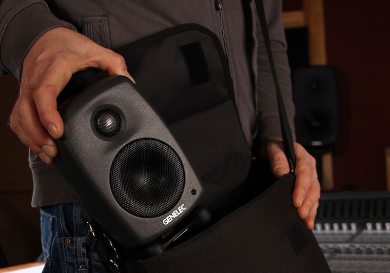 Man putting a Genelec 8010A into a satchel.