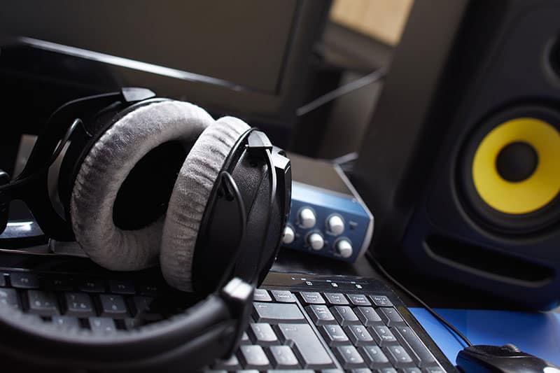 Picture of Studio Monitos next to an audio interface and headphones.