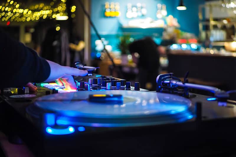 DJ playing with turntables in a bar.