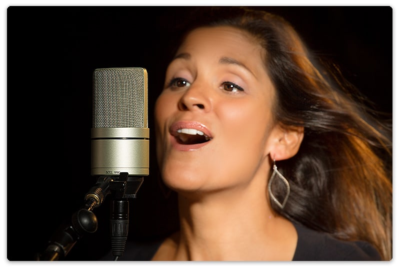 Woman singing into a MXL 990 microphone.