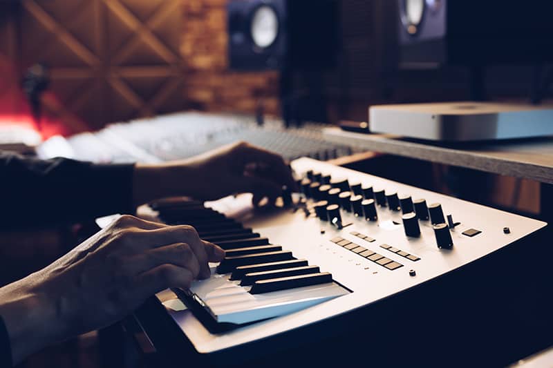 Man working in a music studio on a keyboard.