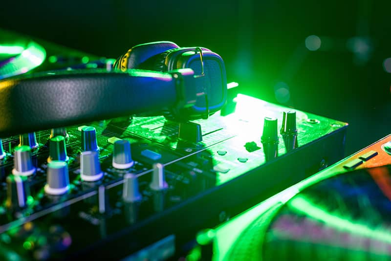 Photo of headphones sitting on top of a DJ controller