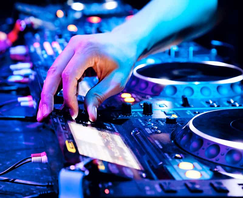 DJ selecting a song on a screen on DJ gear
