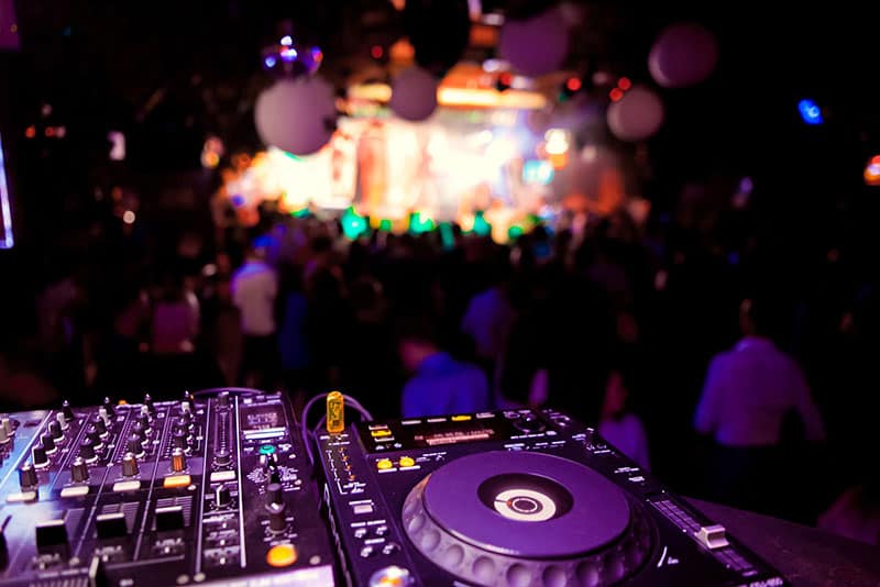 Close up photo of Pioneer DJ gear with a blurred crowd in the background