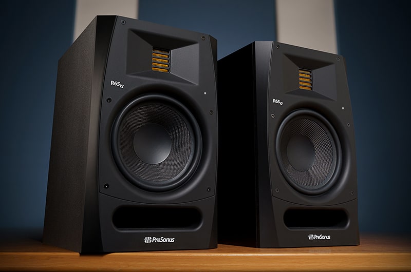 PreSonus R65 V2 studio monitors on a wooden desk.