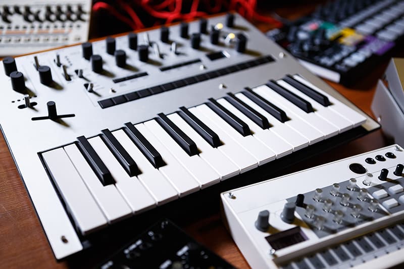 Various pieces of music gear like keyboards and synths.