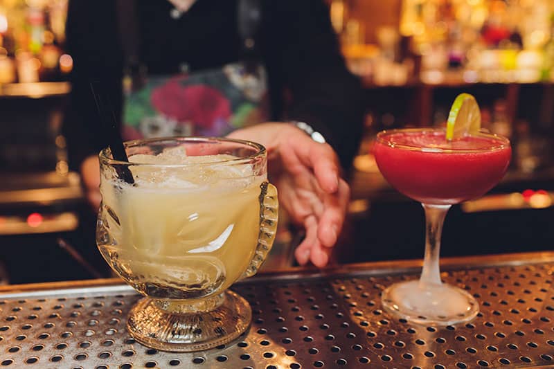 Two cocktails at a bar.