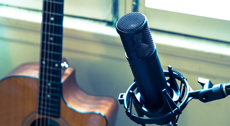 sE Electronics sE2200 microphone with a guitar in the background.