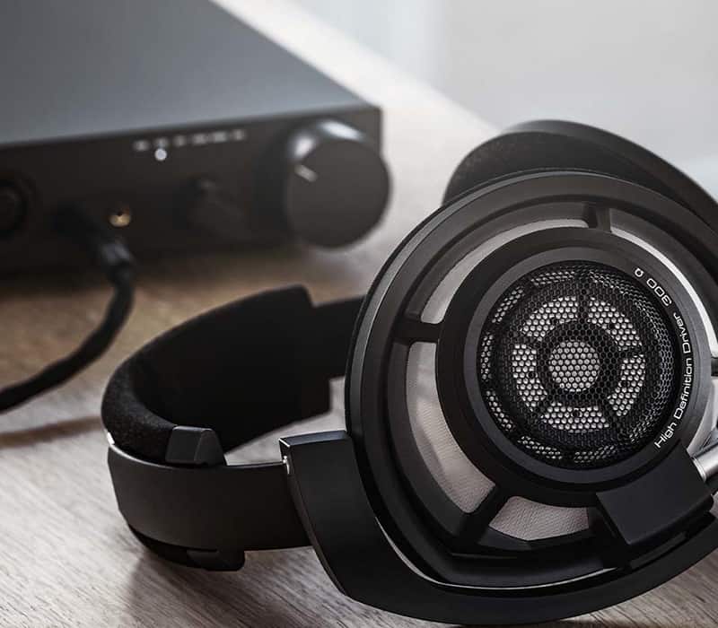 Sennheiser HD 800 S headphones with a headphone amplifier in the background.