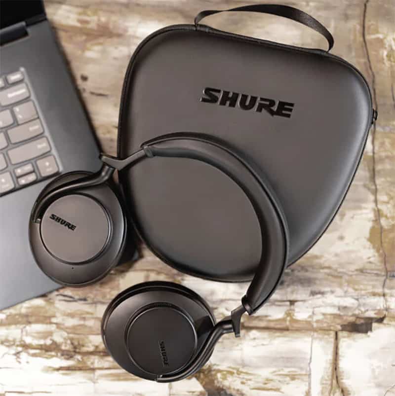 Shure AONIC 50 Gen 2 sitting on top of a case and laptop.