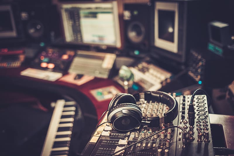 A pair of headphones on top of studio equipment.