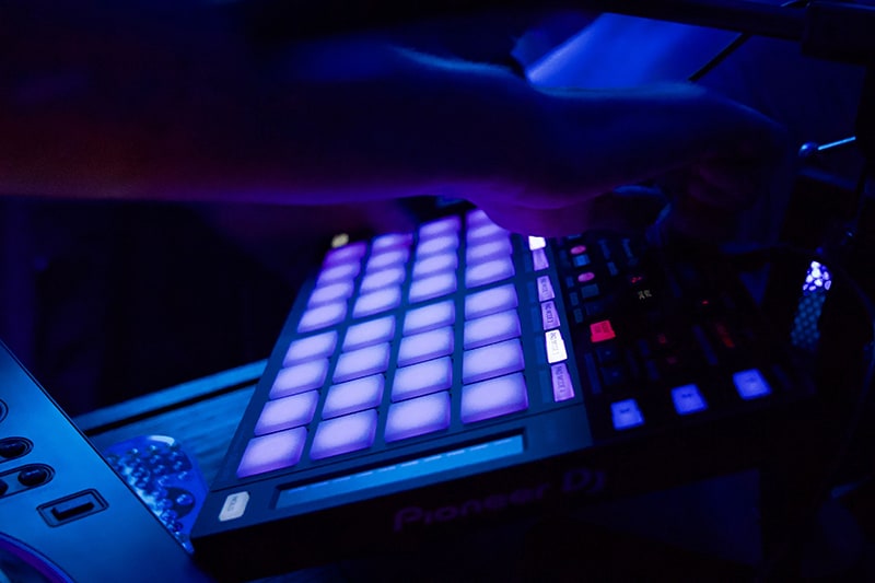 Man using a mixing board in a dark studio.