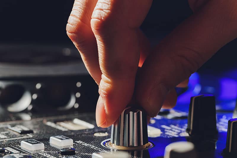 DJ adjusting EQ knob on DJ gear.
