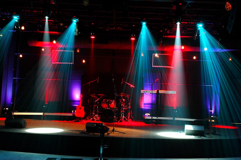 Photo of a stage with musical instruments and speakers.