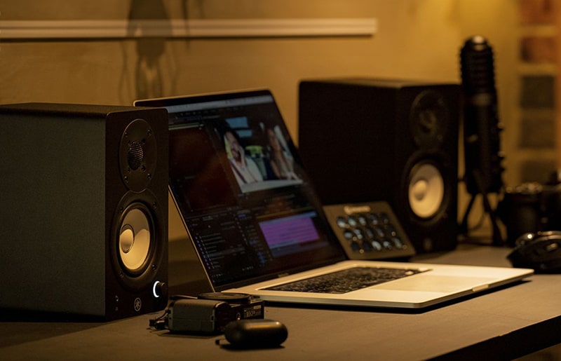 Yamaha HS4 studio monitors sitting on a desk.