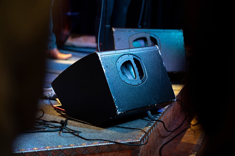 Photo of a worn speaker on a stage.