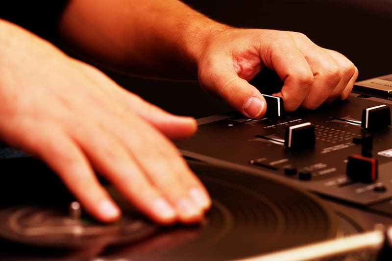 DJ using a crossfader and scratching a vinyl record.