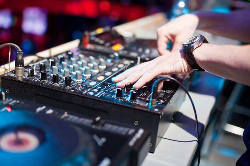 DJ using a DJ mixer in a nightclub.