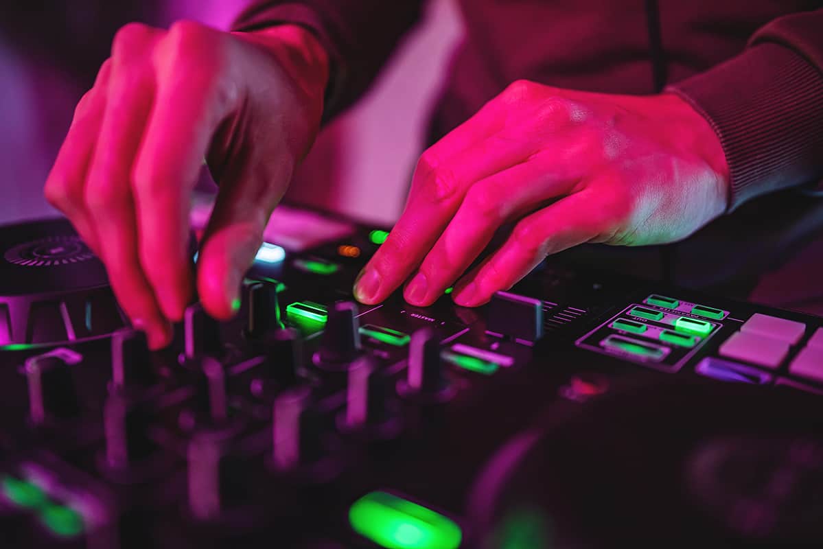 Close-up photo of a DJ using a DJ controller.