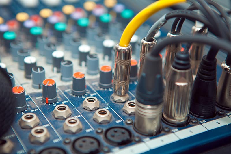 Audio cables plugged into a mixer board