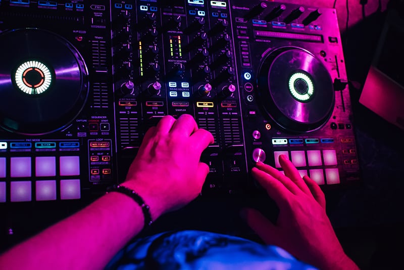 DJ using a DJ controller in a nightclub.