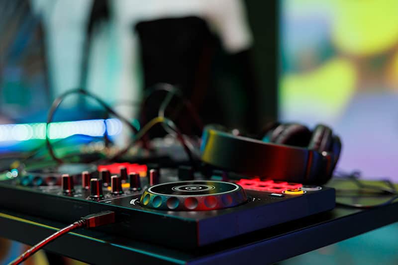 DJ controller sitting on a desk with headphones.