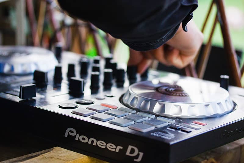 Close-up photo of a DJ using a DJ controller.