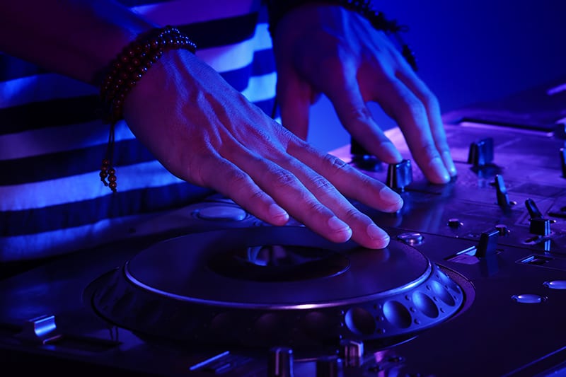 Close-up of a DJ using DJ equipment.