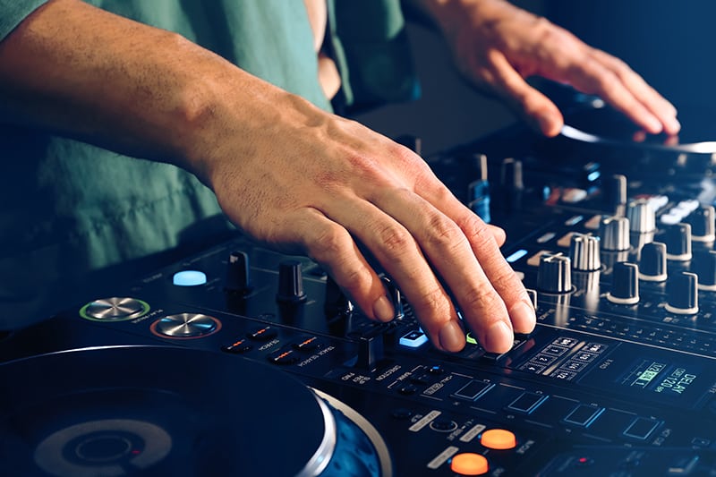 Close-up photo of a DJ using DJ equipment.