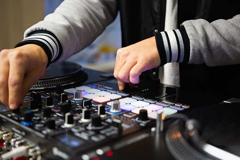 Close-up photo of a DJ using DJ equipment.