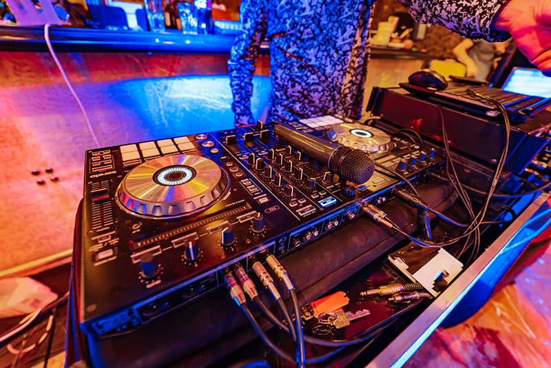 DJ playing at a party with a DJ controller.