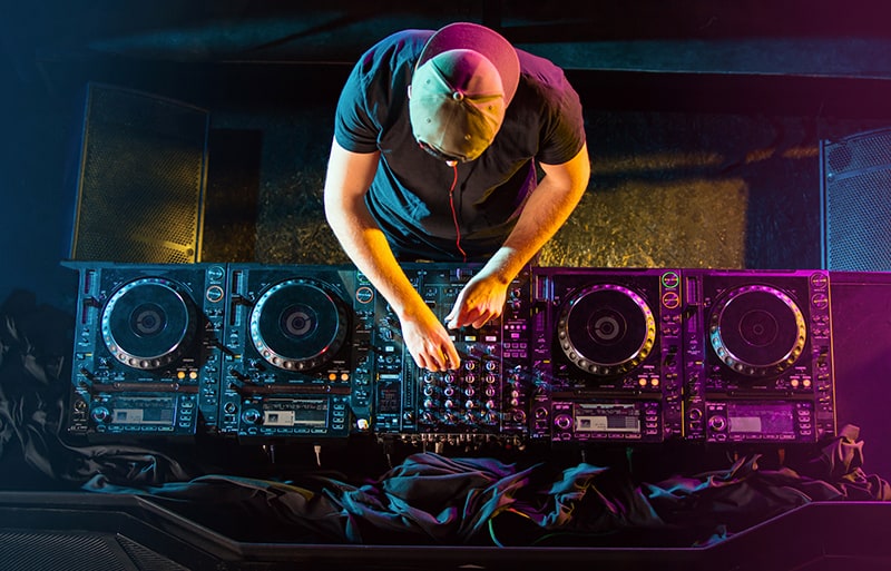 Top view of a DJ using a DJ mixer and four media players.