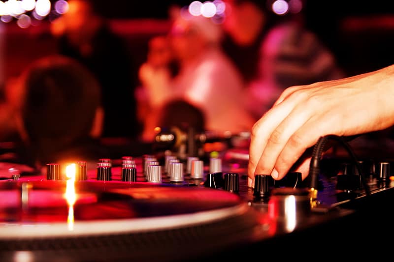 Close up view of a turntable and DJ mixer.