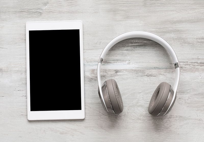 Tablet and headphones on a wooden background