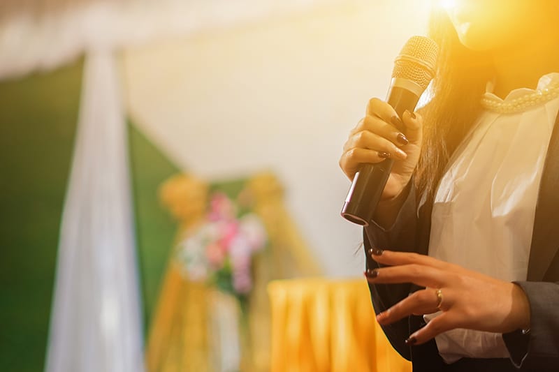Woman with a microphone making a presentation with a blurred background