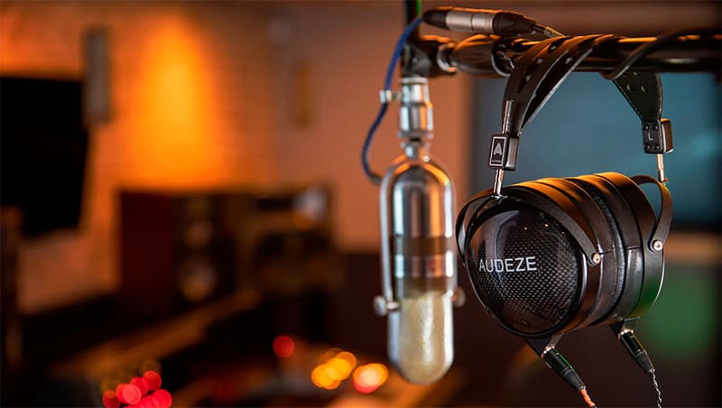Audeze headphones hanging on a microphone stand.