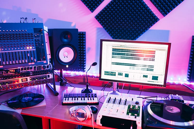 Music studio with a variety of components including speaker, keyboard and turntable.