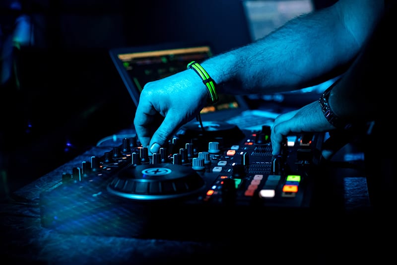 DJ performing with a DJ controller and laptop.